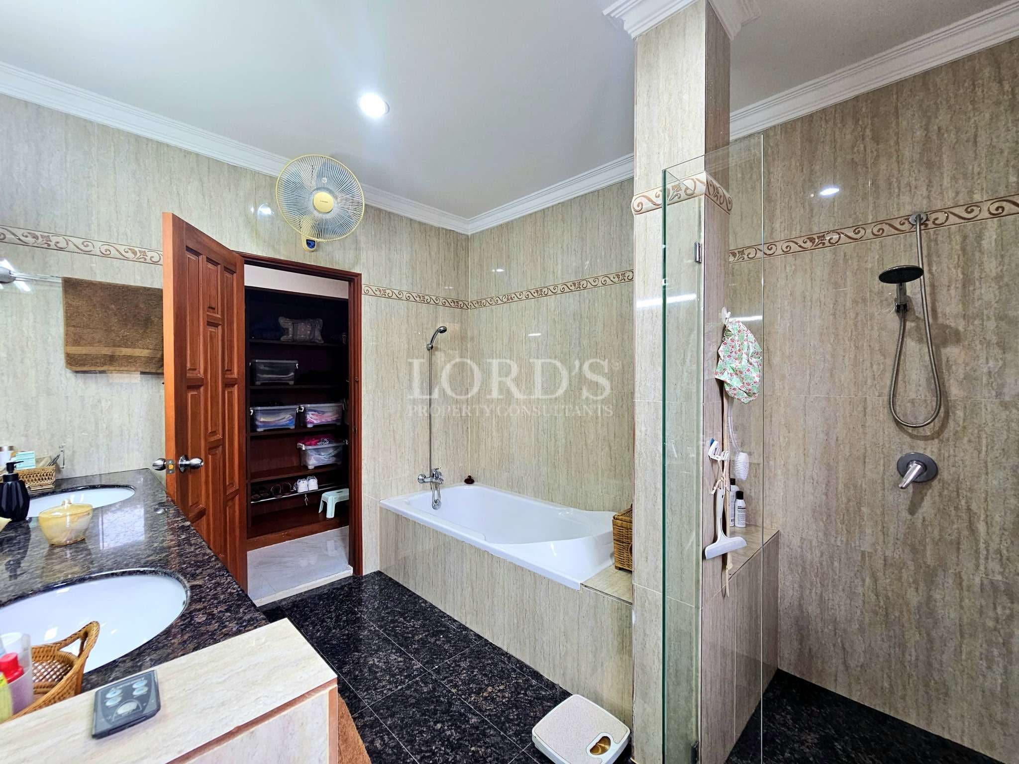 Spacious modern bathroom with bathtub, glass shower enclosure, granite vanity, and built-in storage.
