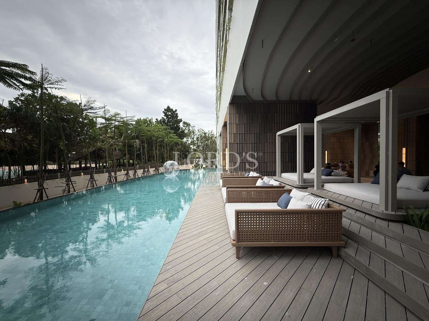 Luxury swimming pool with poolside loungers and private cabanas in a modern residence.