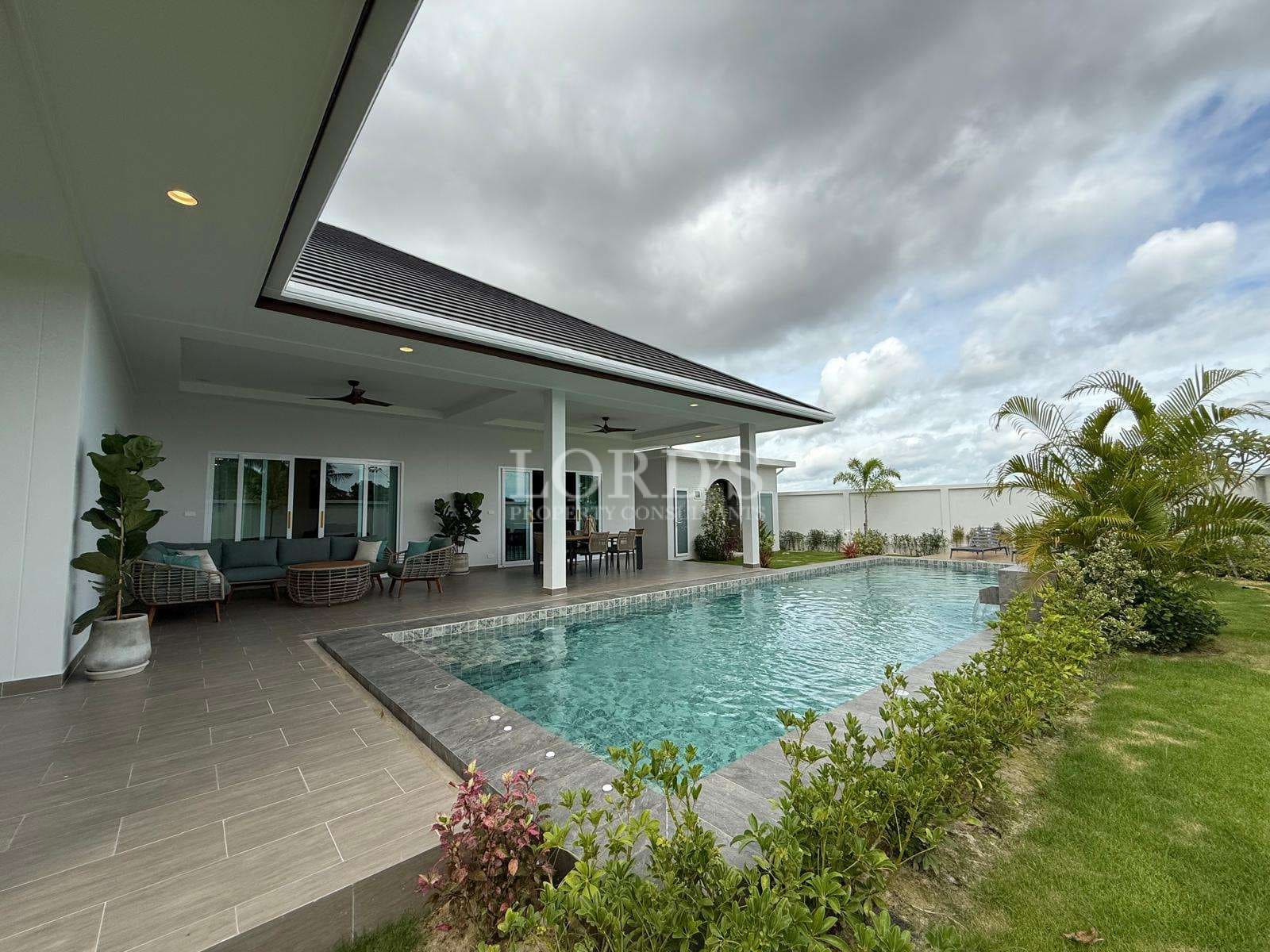 Luxury villa with private swimming pool, covered patio seating, and landscaped garden.