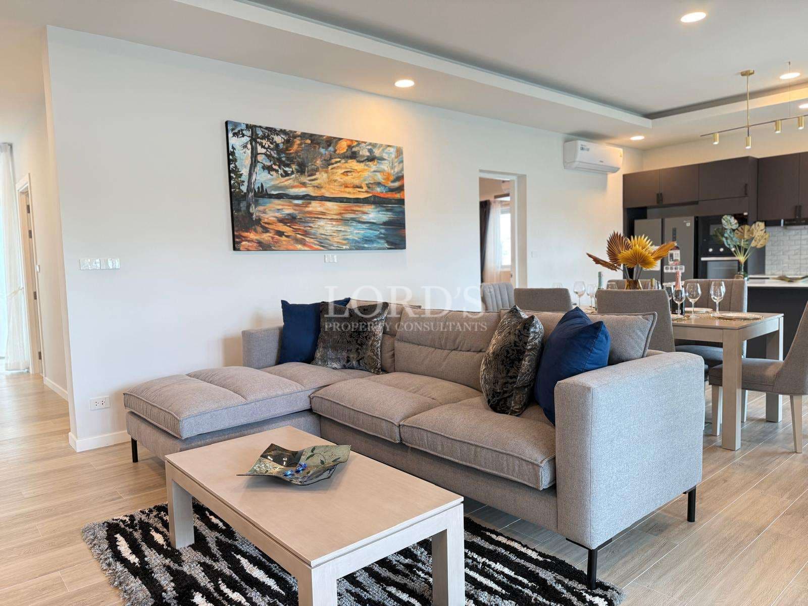 Modern open-plan living room with comfortable sofa, dining area, and contemporary interior design.