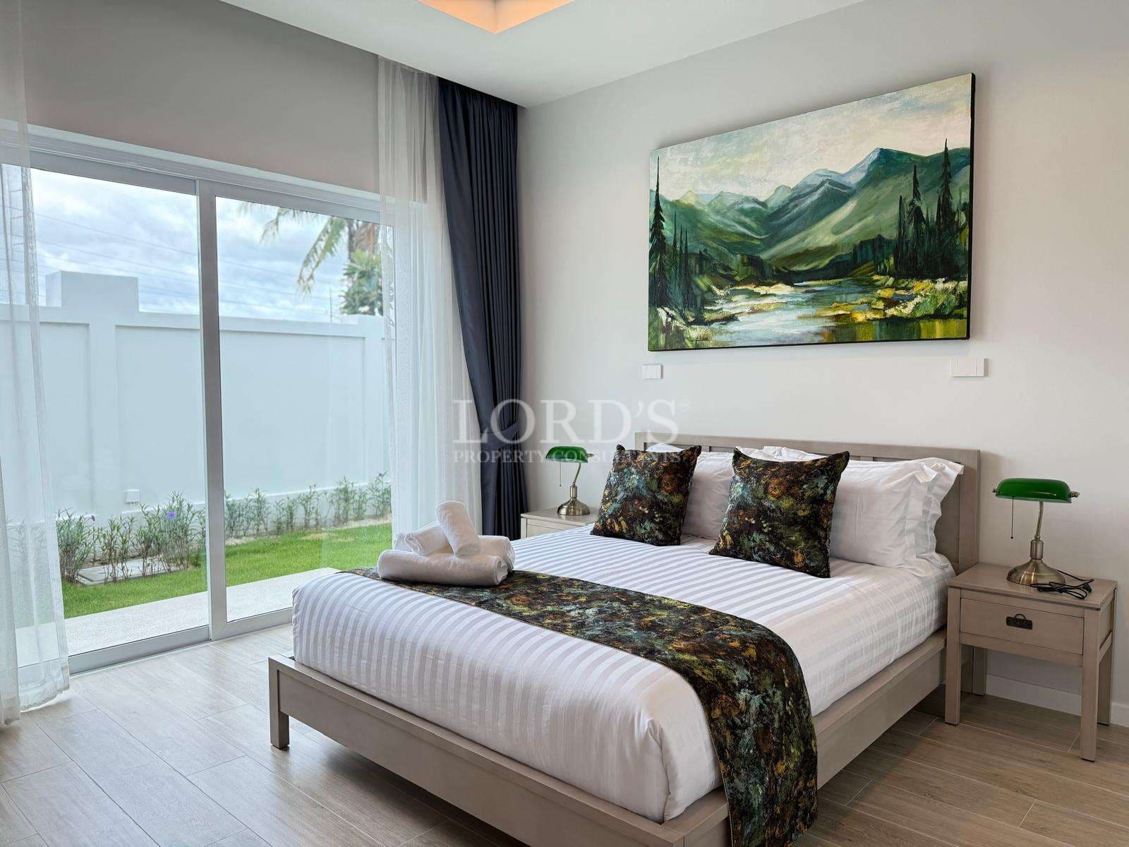 Modern luxury bedroom with king-size bed, large glass doors, and garden view.