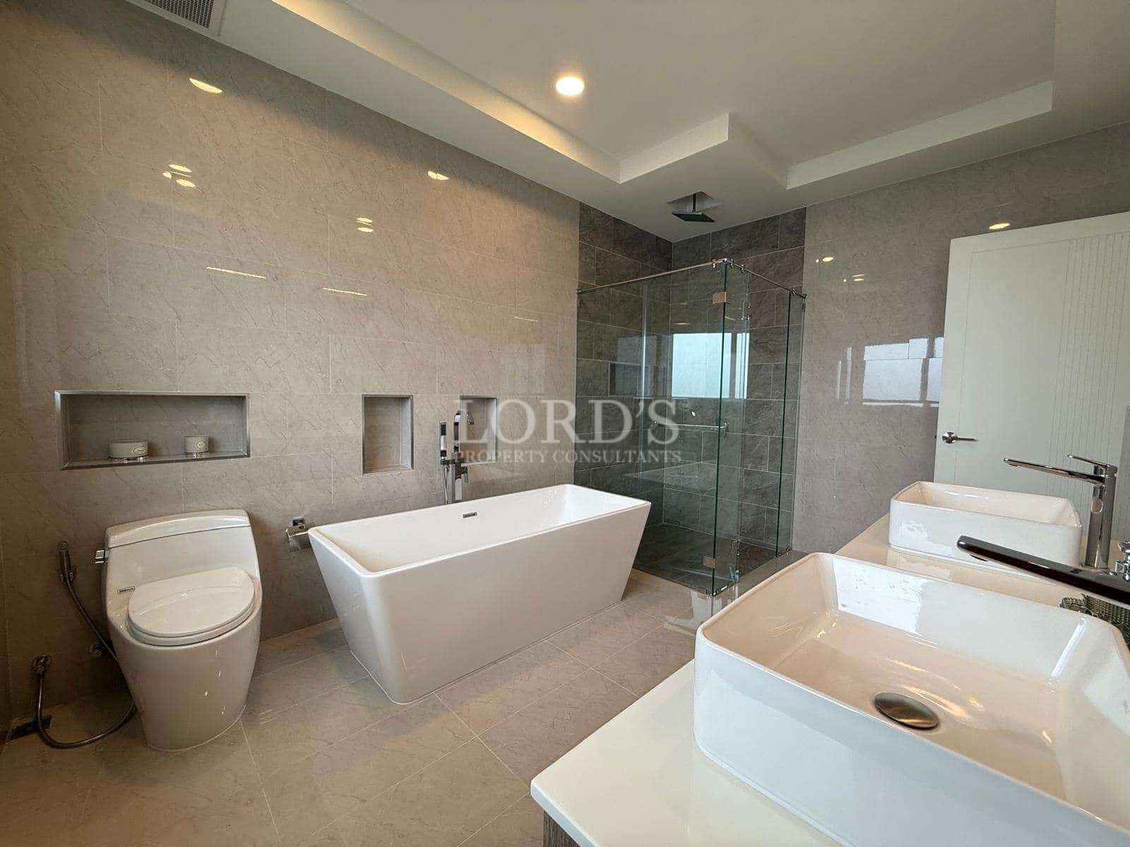Modern luxury bathroom with freestanding bathtub, glass shower, and elegant vanity sink.