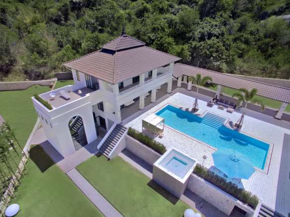 Aerial view of a luxury hillside villa with private swimming pool, terrace lounge area, and landscaped garden.