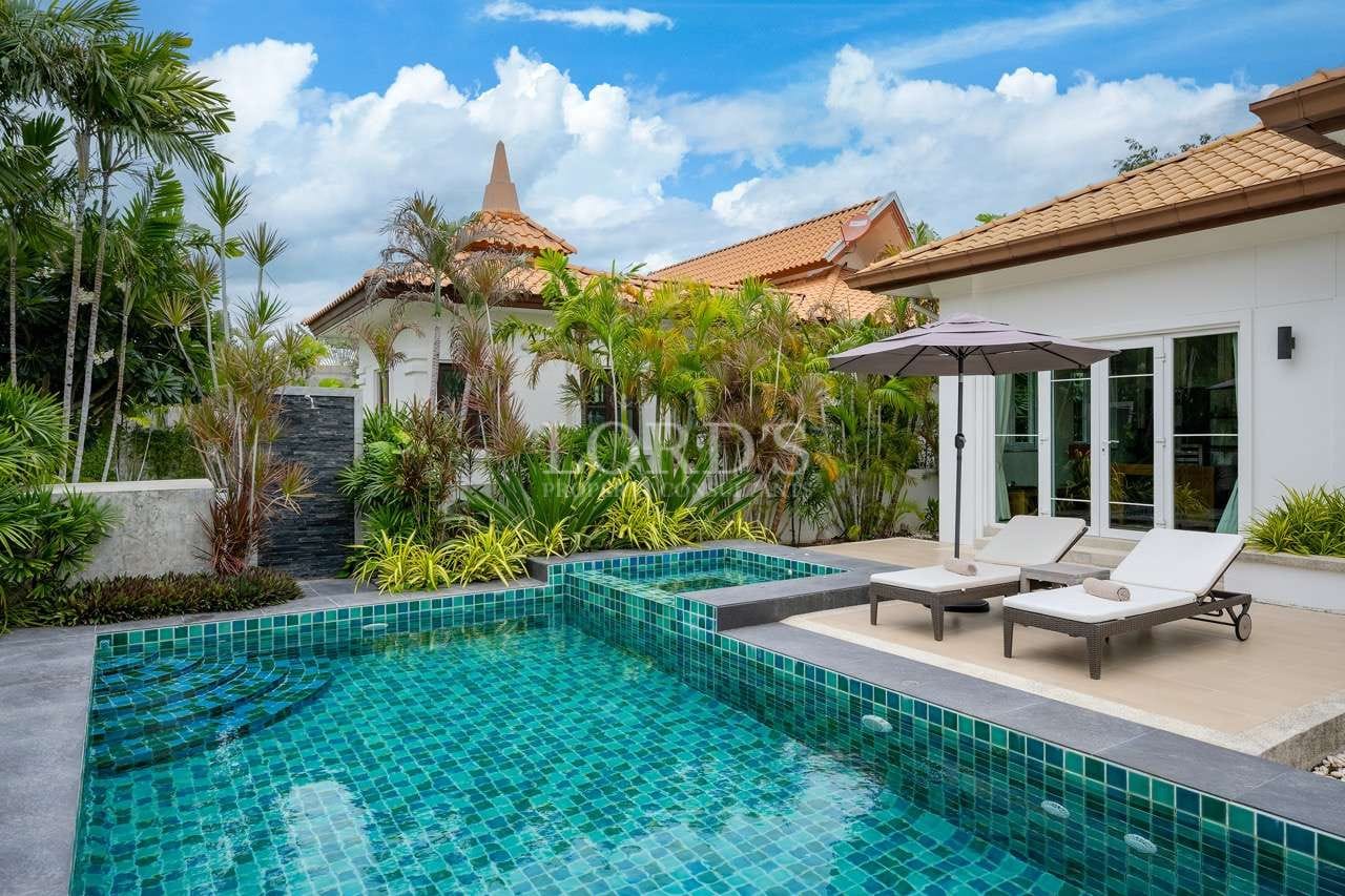 Luxury villa with private swimming pool, sun loungers, poolside umbrella, and lush tropical landscaping.