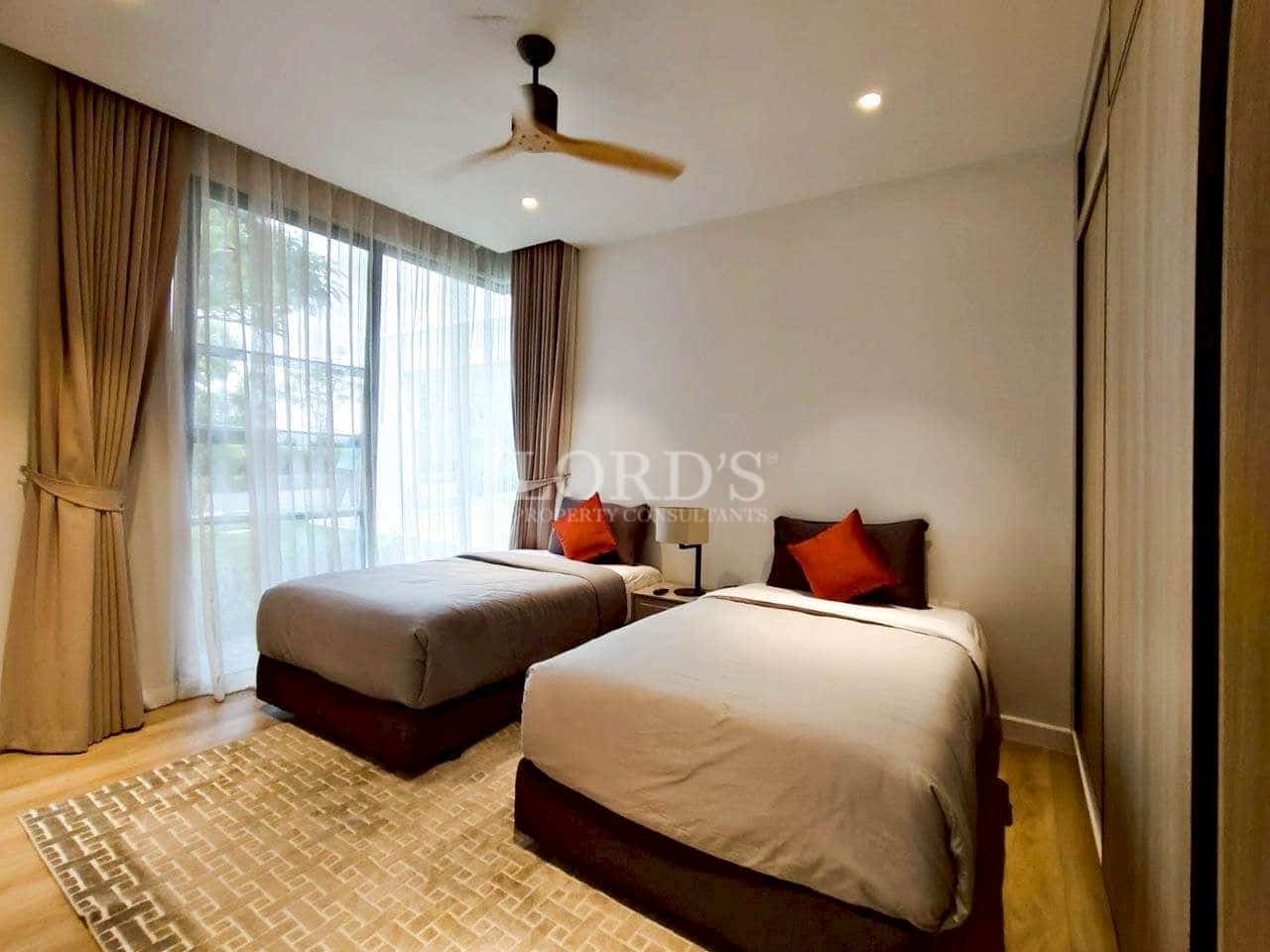 Twin bedroom with two single beds, ceiling fan, soft lighting, and large window with curtains