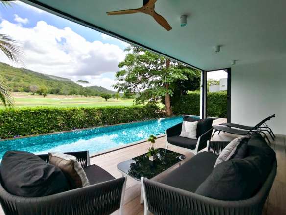 Covered poolside lounge with private swimming pool, outdoor seating, and scenic golf course views