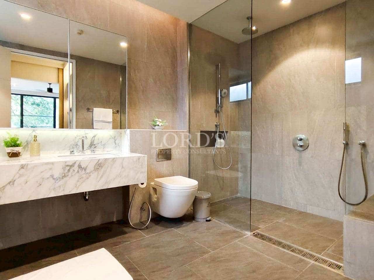 Modern bathroom with marble vanity, glass-enclosed walk-in shower, and minimalist fixtures