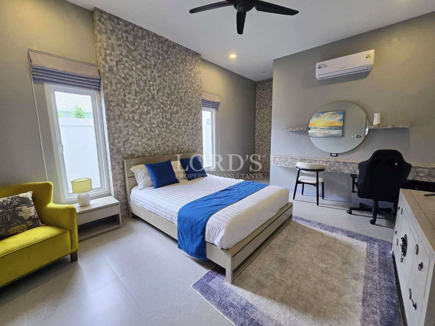 Modern bedroom with study area, single bed, accent wall, desk, air conditioning, and contemporary decor.