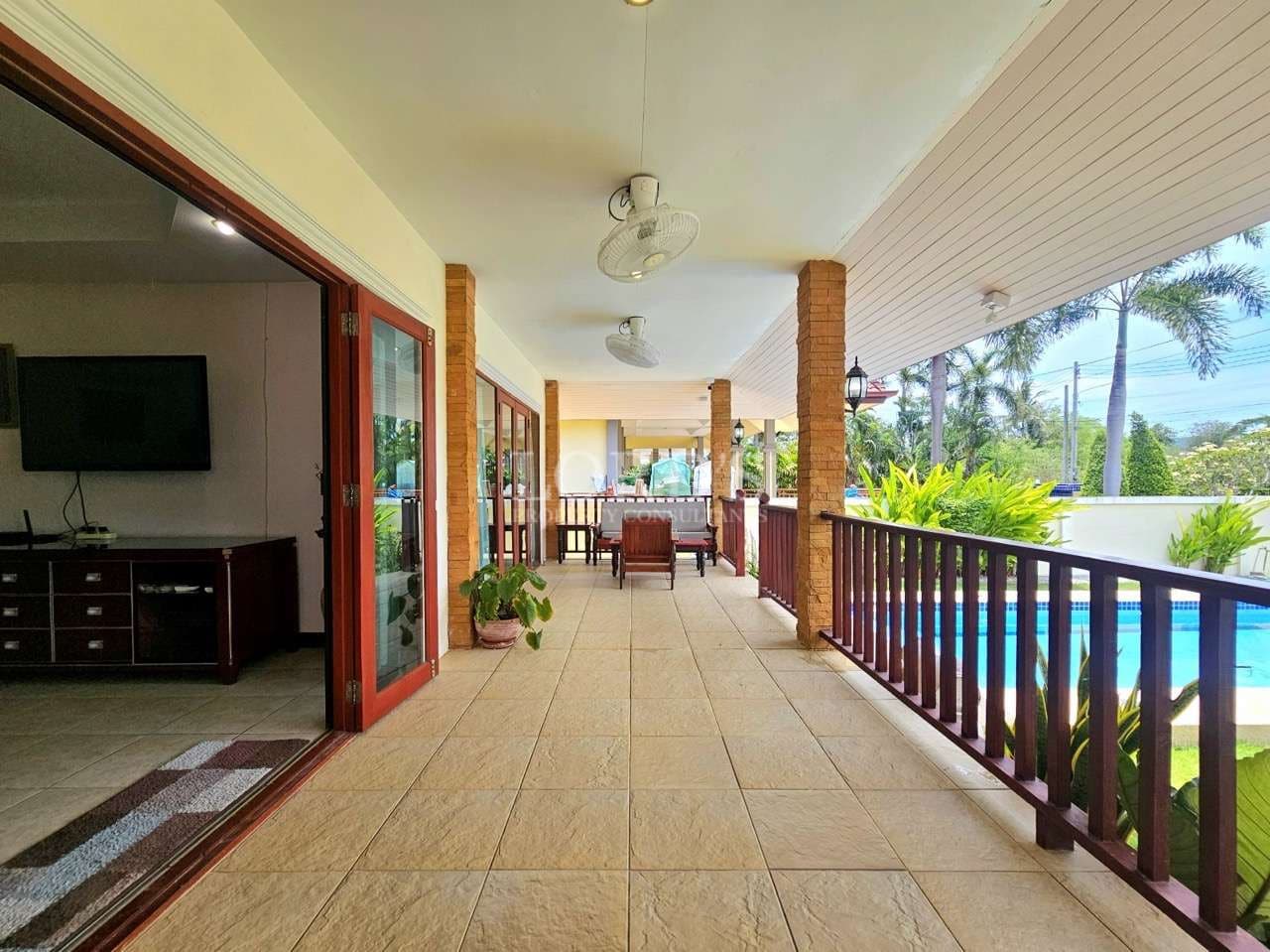 Spacious patio overlooking a pool.