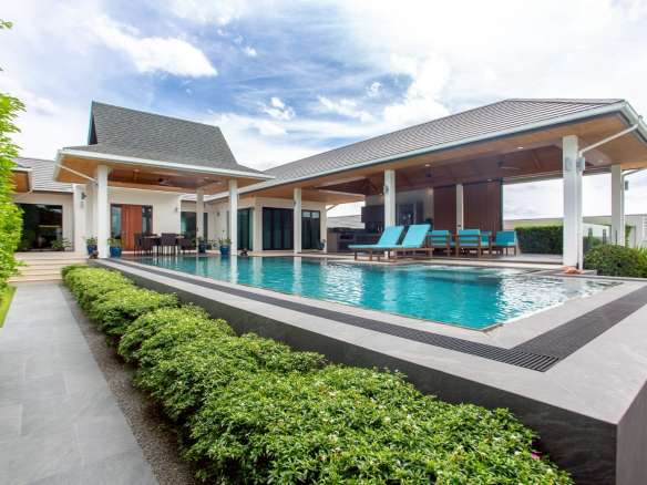 Luxury modern villa with private swimming pool, covered terrace, and outdoor lounge seating.