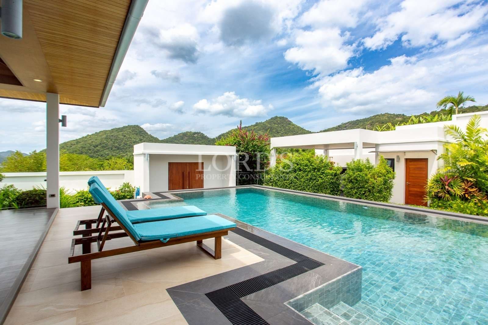 Luxury private villa swimming pool with sun loungers and scenic mountain views.