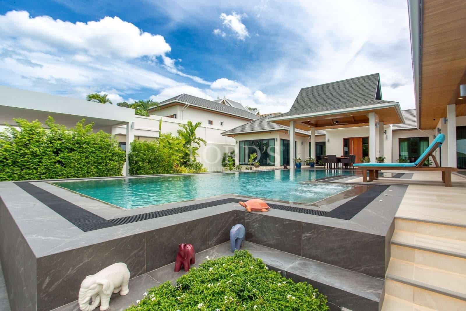 Luxury private villa with swimming pool, sun deck, and covered outdoor dining area.