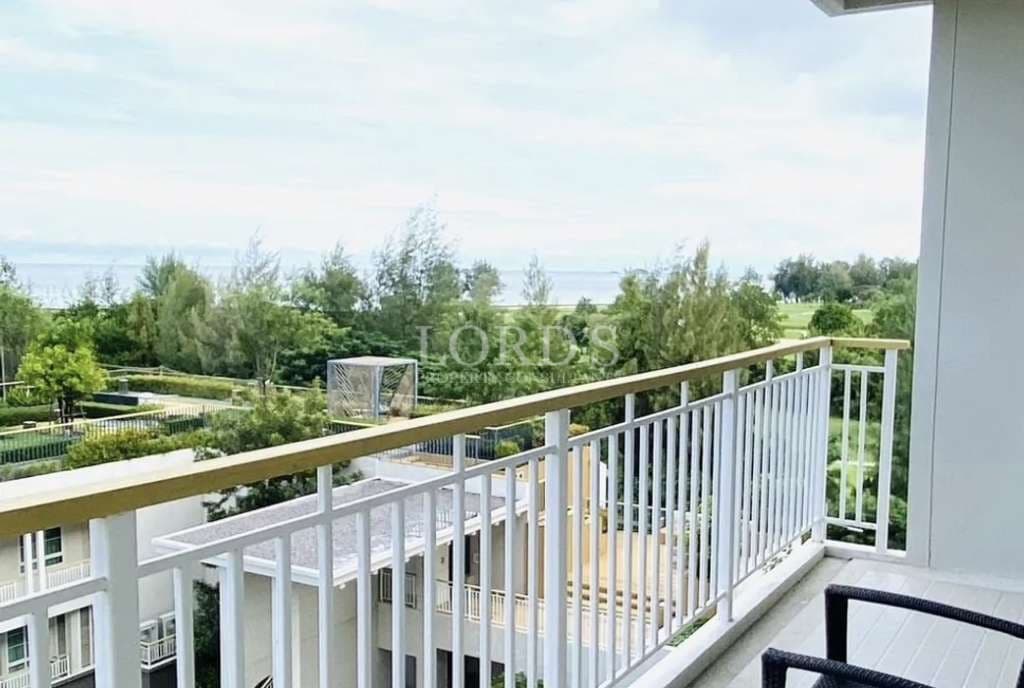 Private balcony with railing overlooking landscaped gardens, greenery, and open natural views.