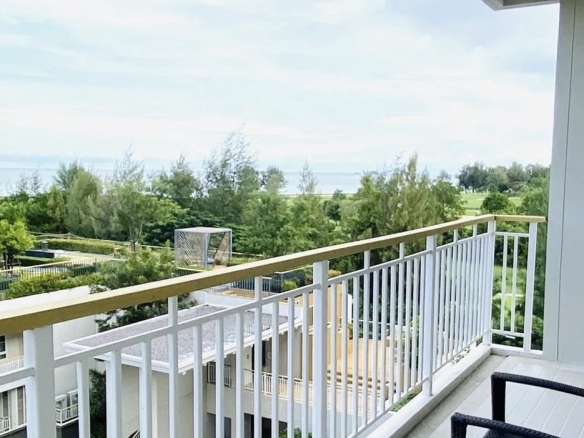 Private balcony with railing overlooking landscaped gardens, greenery, and open natural views.