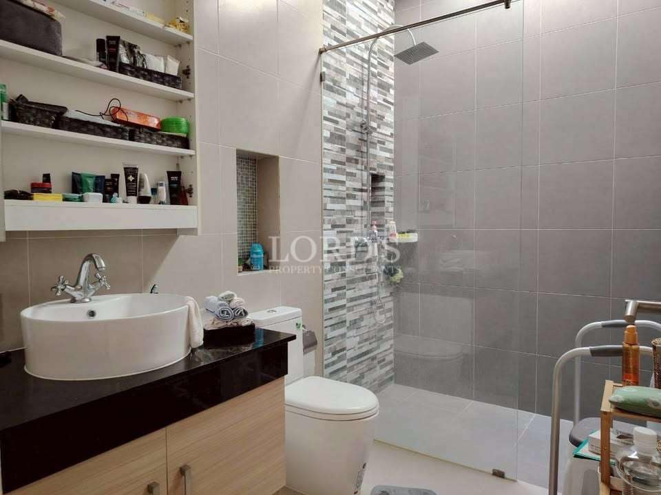 Modern bathroom with walk-in glass shower, mosaic tile accent wall, vanity sink, and open shelving.