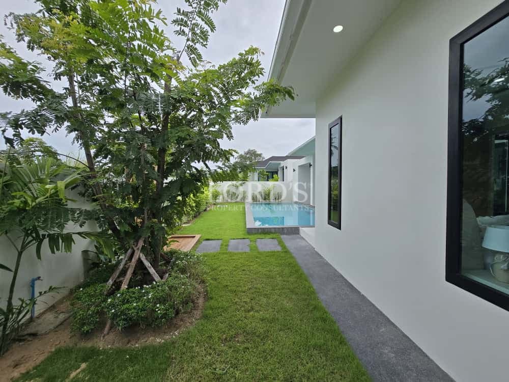 Lush garden with pathway and house