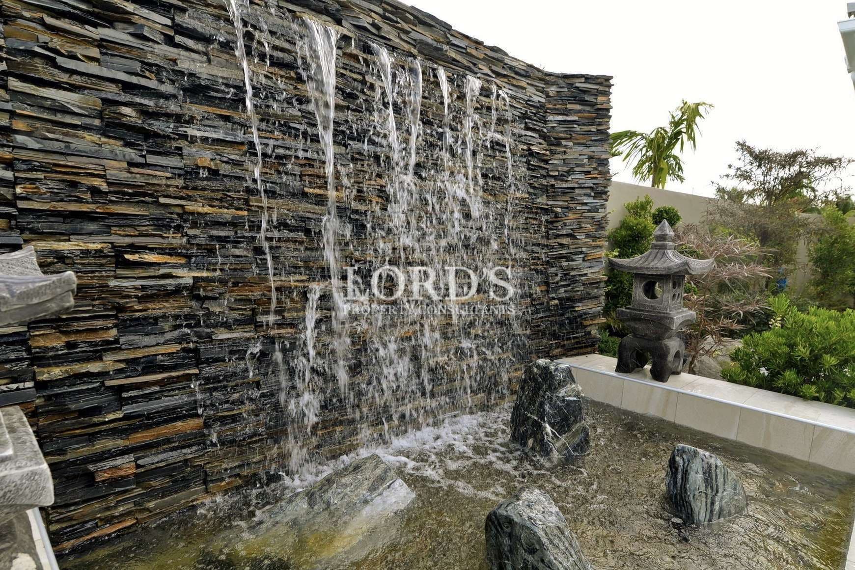 Waterfall feature with stone backdrop.