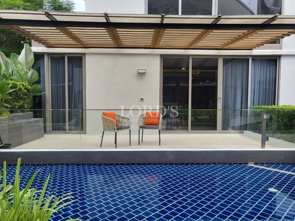 Private pool terrace with pergola and glass railing.