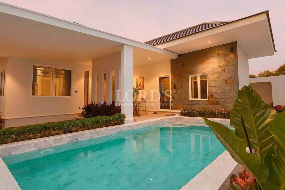 Luxury villa with private swimming pool, covered terrace, and modern exterior at dusk.