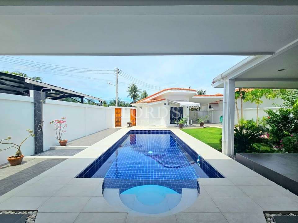 Modern pool surrounded by greenery.