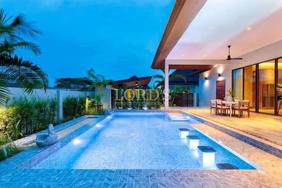 Luxury villa with private swimming pool, outdoor seating area, and ambient evening lighting.