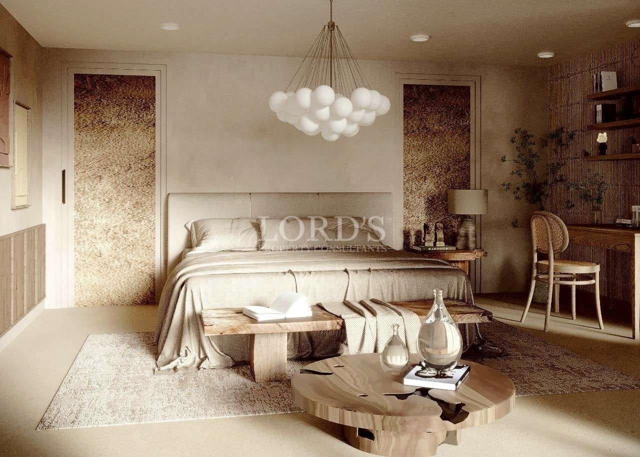 Modern luxury bedroom with neutral tones, upholstered bed, and artistic pendant lighting.