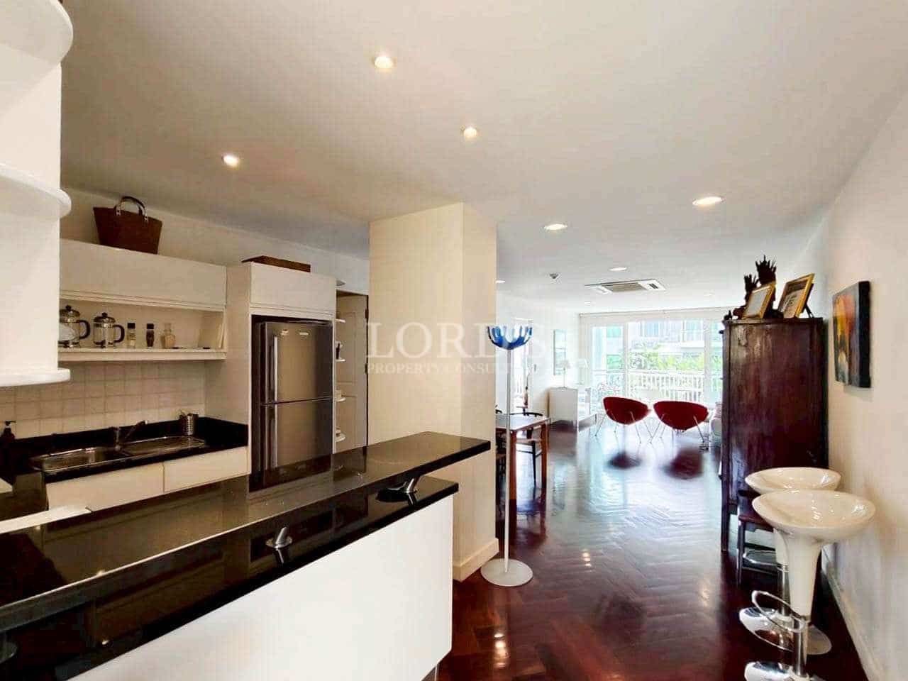 Open-plan kitchen and living area with black granite island and modern dining space.