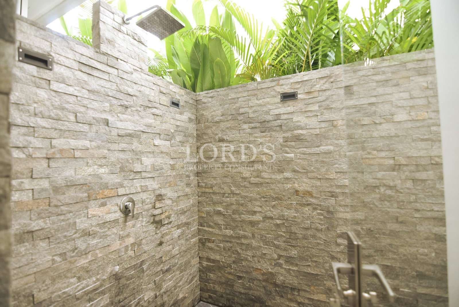 Modern outdoor shower with stone walls