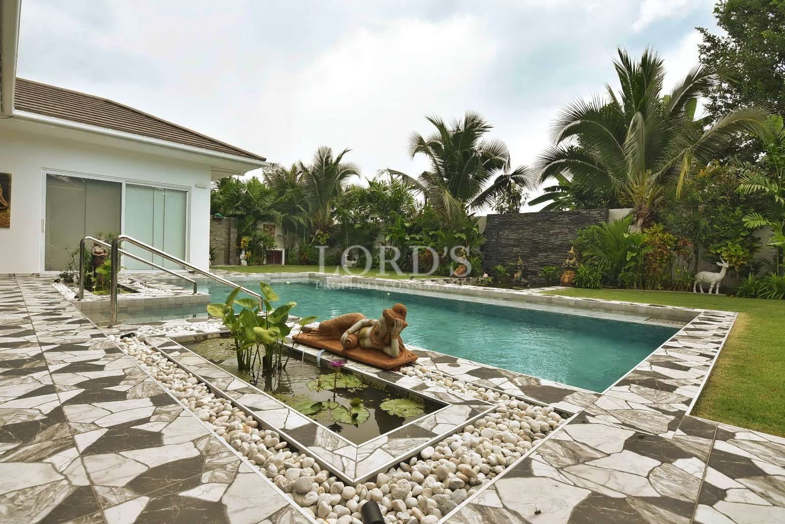 Luxurious poolside with tropical landscaping.