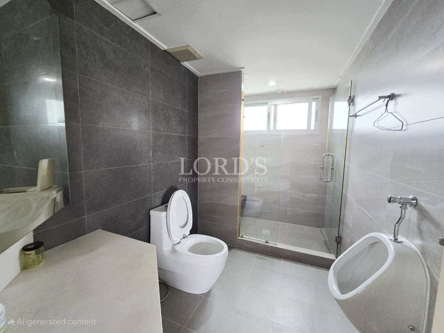 Modern bathroom with walk-in glass shower, toilet, and wall-mounted urinal.