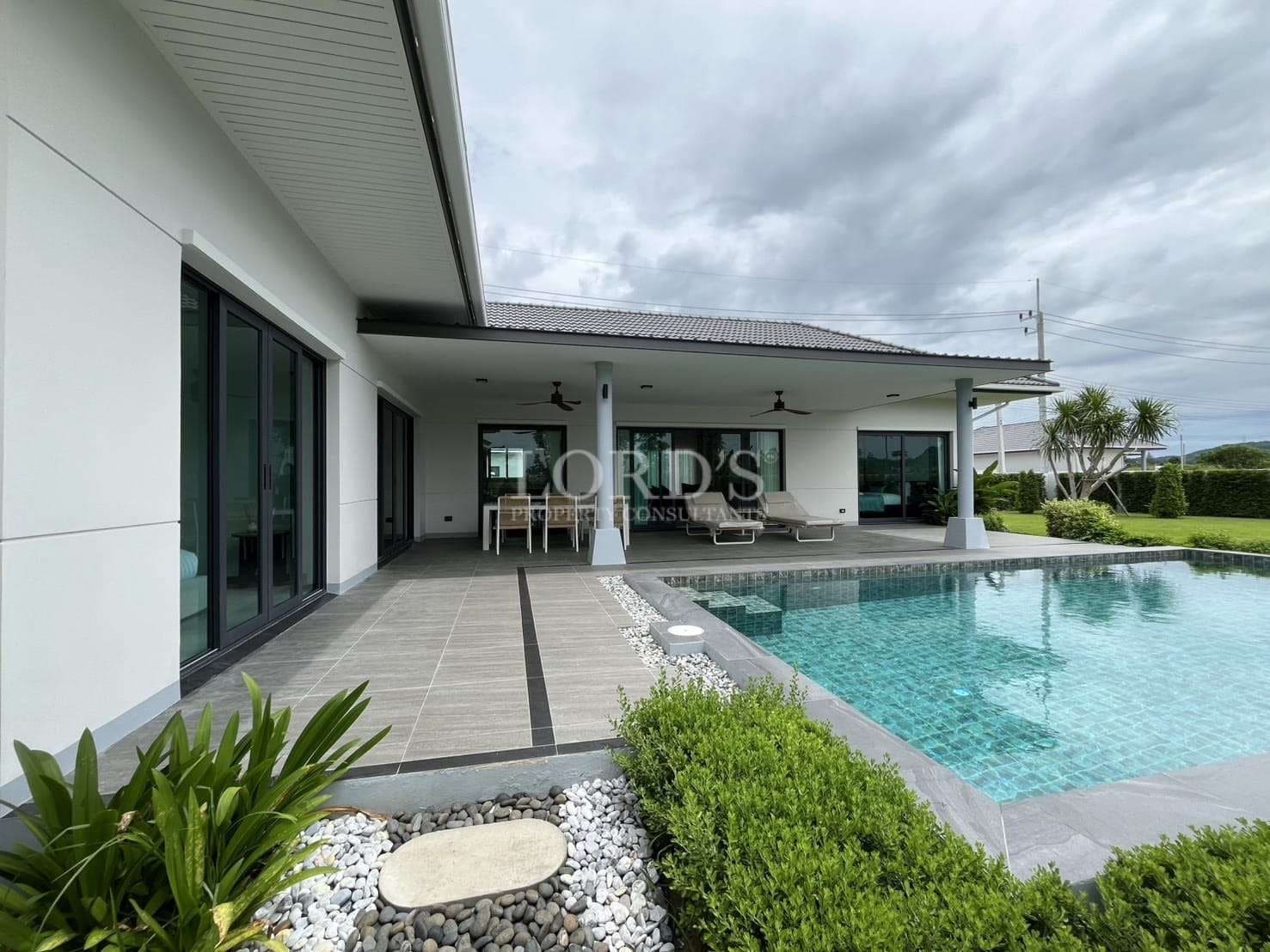 Modern single-story villa with covered terrace and private swimming pool.