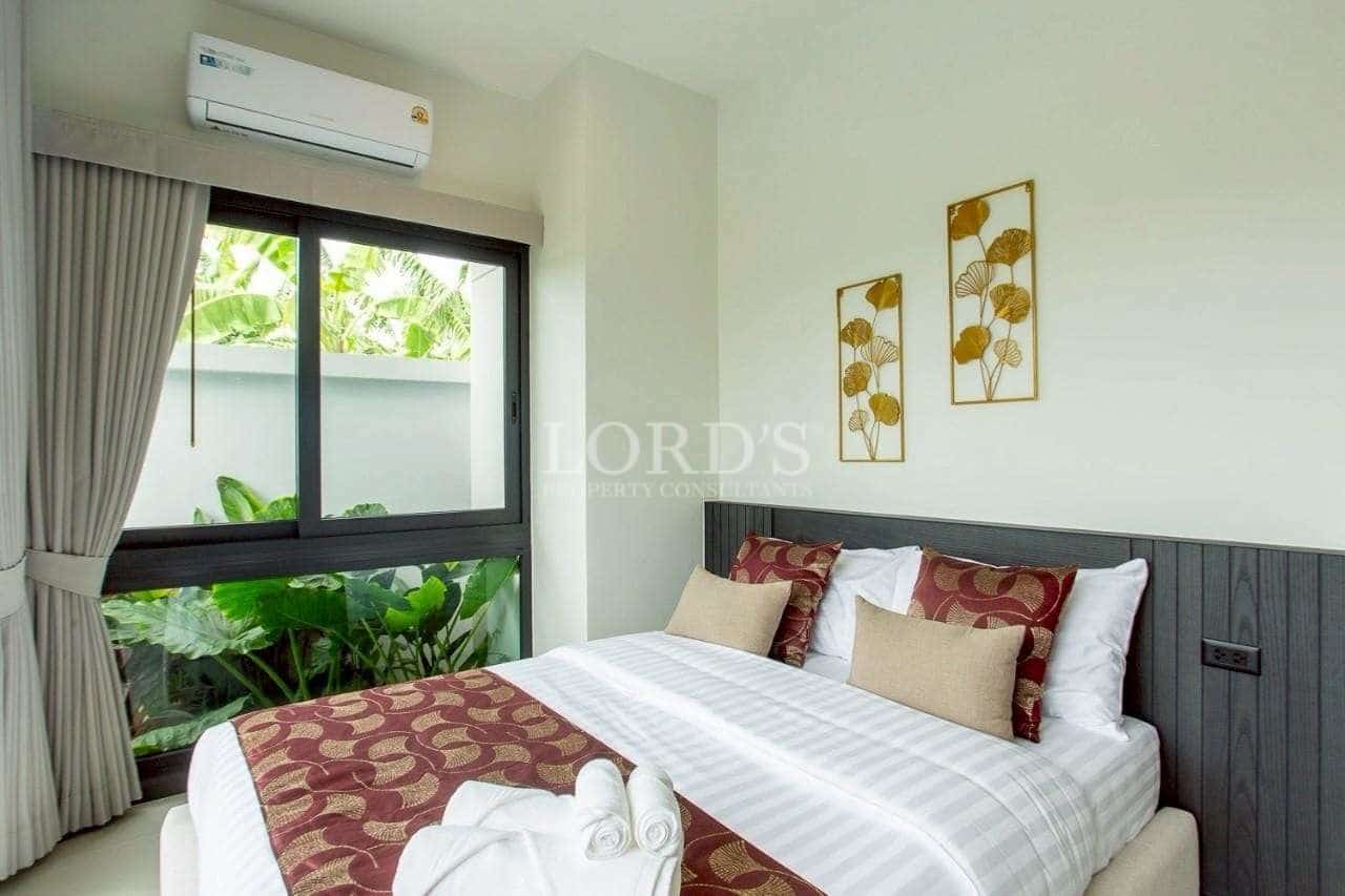 Bright modern bedroom with garden view, neutral tones, and contemporary wall décor.