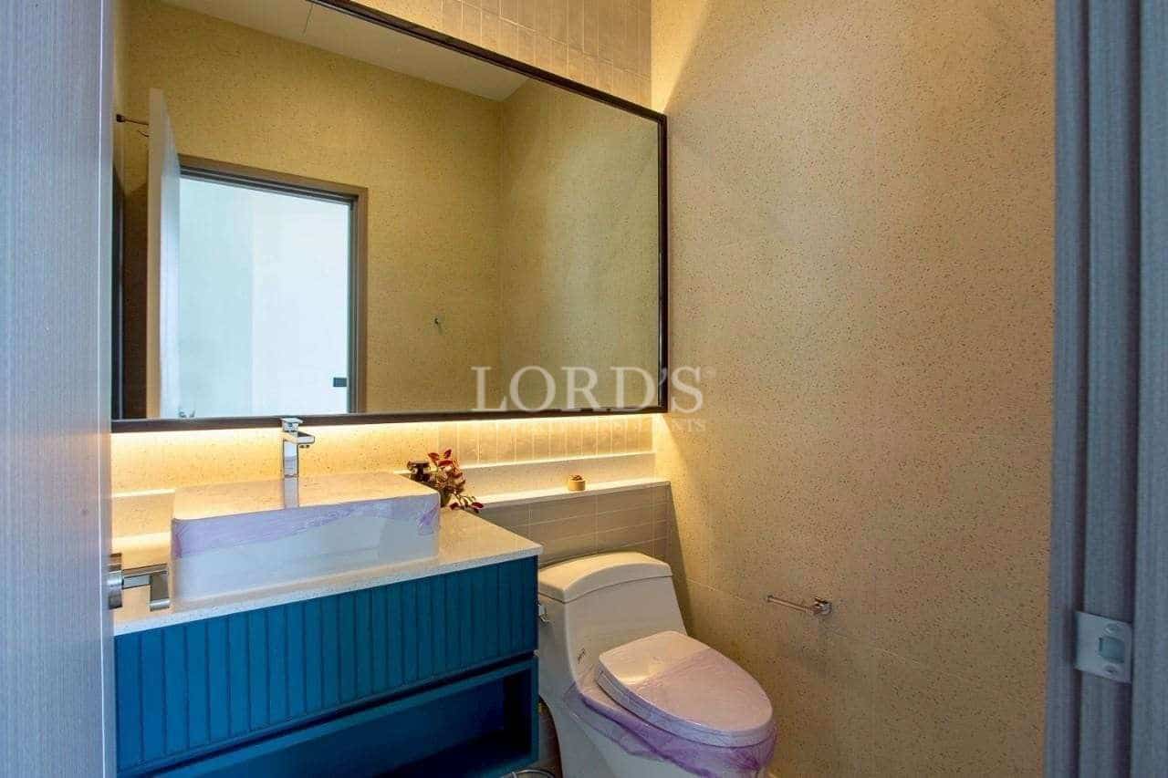Modern guest bathroom with floating vanity, backlit mirror, and compact toilet.