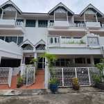 Front exterior of a multi-level townhouse with balconies, white facade, and gated entrance.