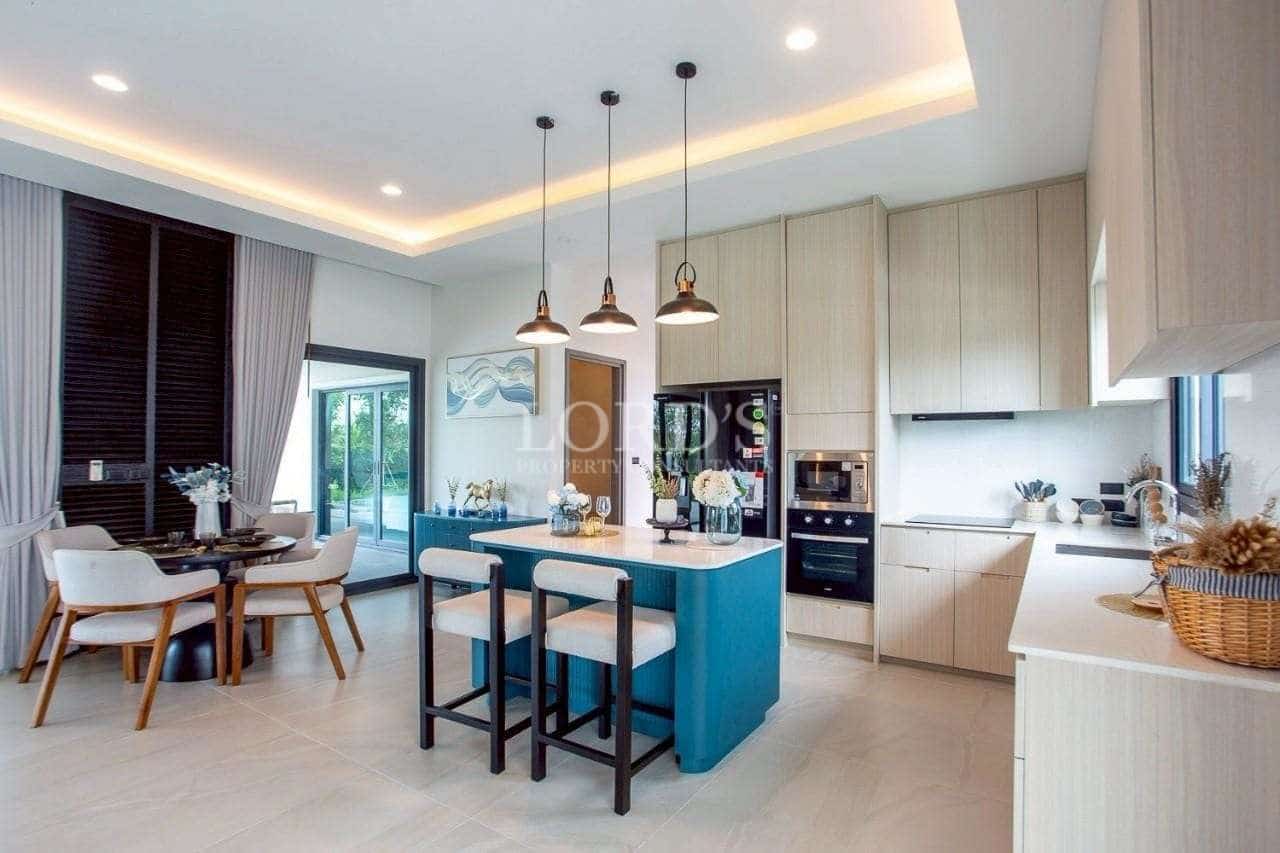 Modern open-plan kitchen with central island, pendant lighting, and adjacent dining area.