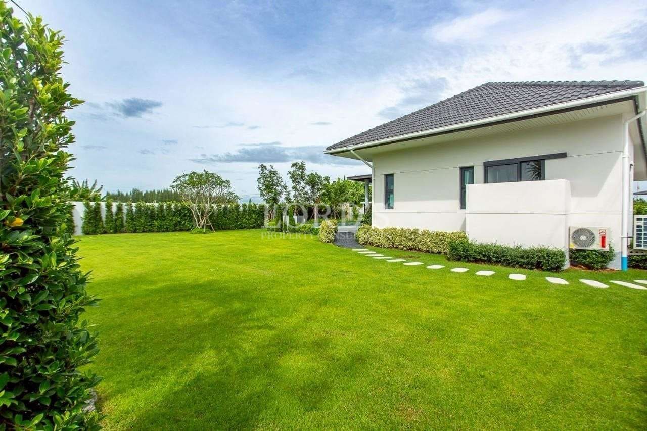 Spacious private garden with manicured lawn beside a modern single-story villa.
