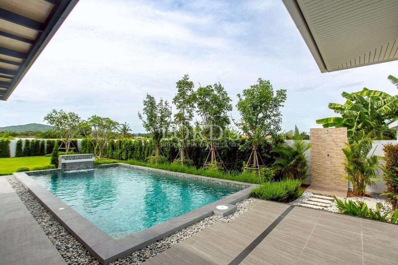 Private swimming pool with landscaped garden, outdoor shower, and modern tiled terrace.