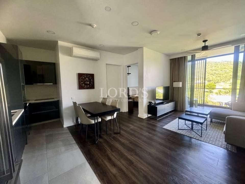 Open-plan living and dining area with modern kitchen, large windows, and mountain views.