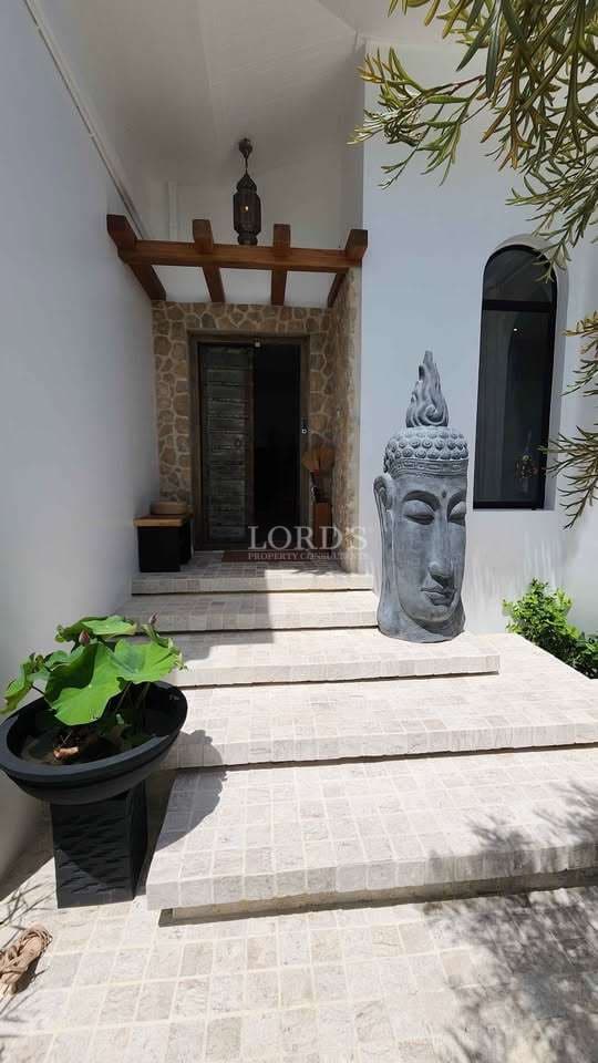 Entrance with Buddha statue and plants