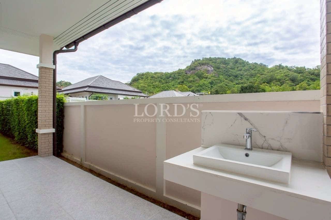 Outdoor covered terrace with built-in sink and mountain view.