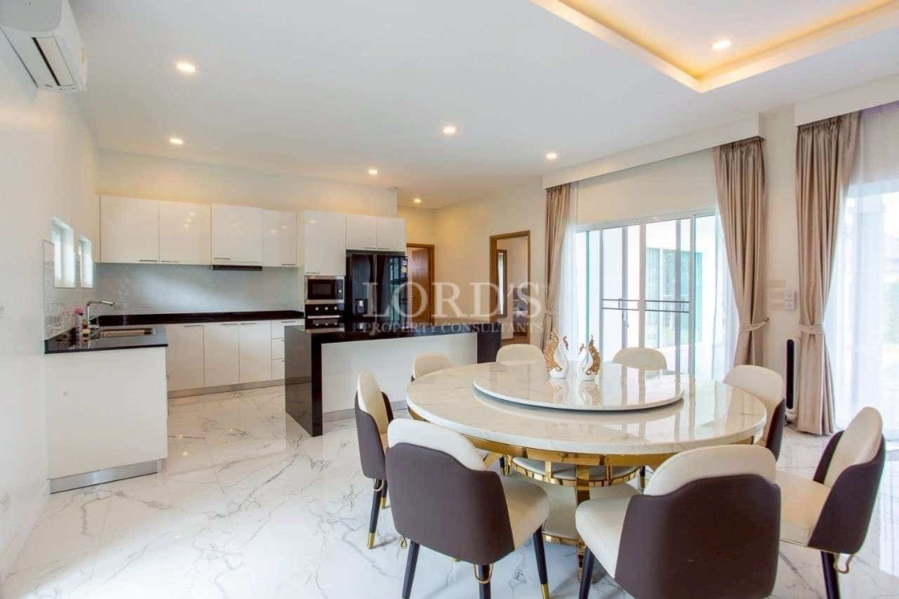 Modern open-plan dining and kitchen area with marble flooring and island counter.