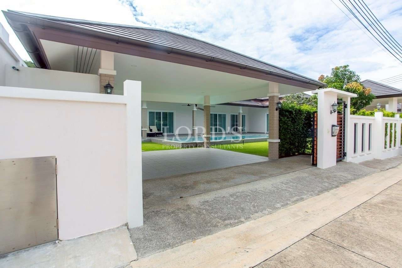 Covered carport and gated entrance of a modern single-storey villa.