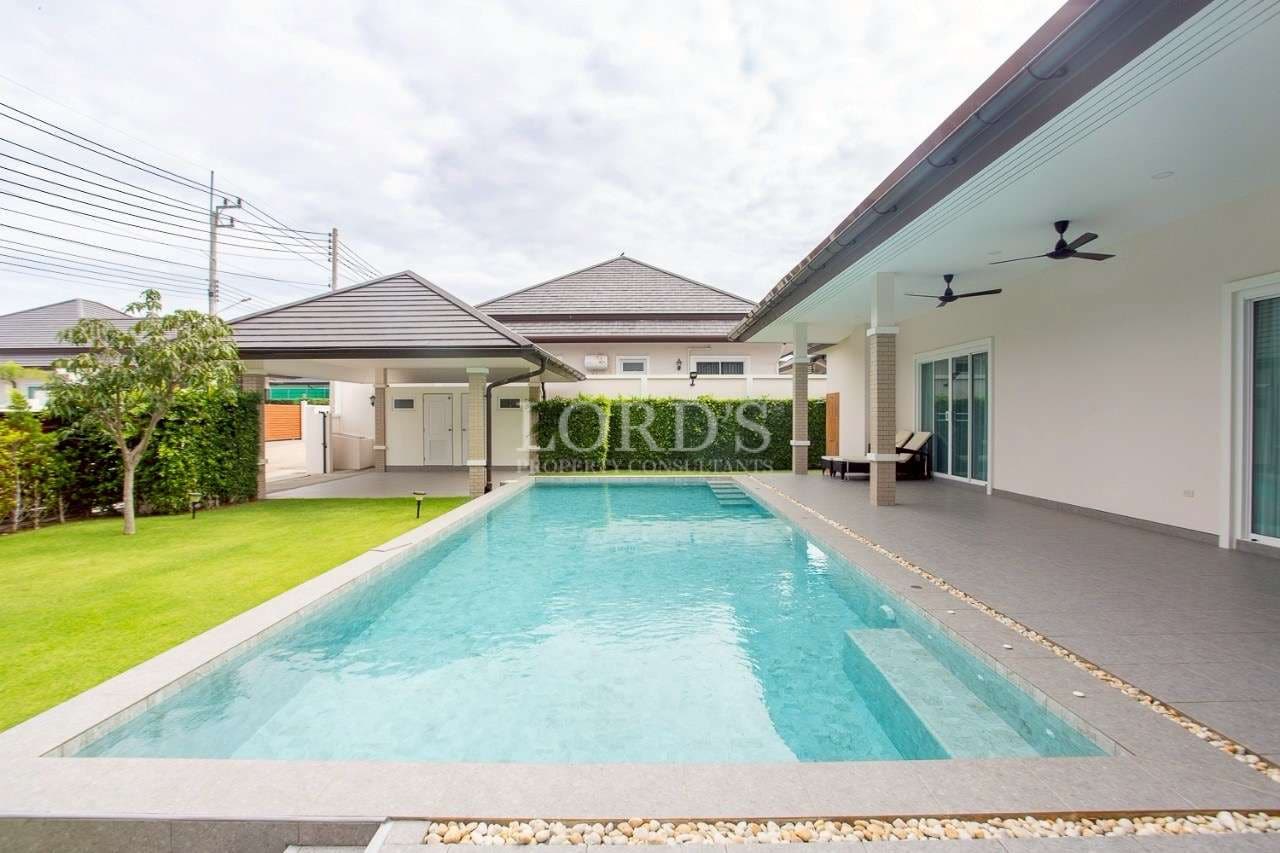 WhatsApp Image 2025-11-09 at 09.14.42 Modern single-story villa with a private swimming pool, covered patio, ceiling fans, and landscaped garden.