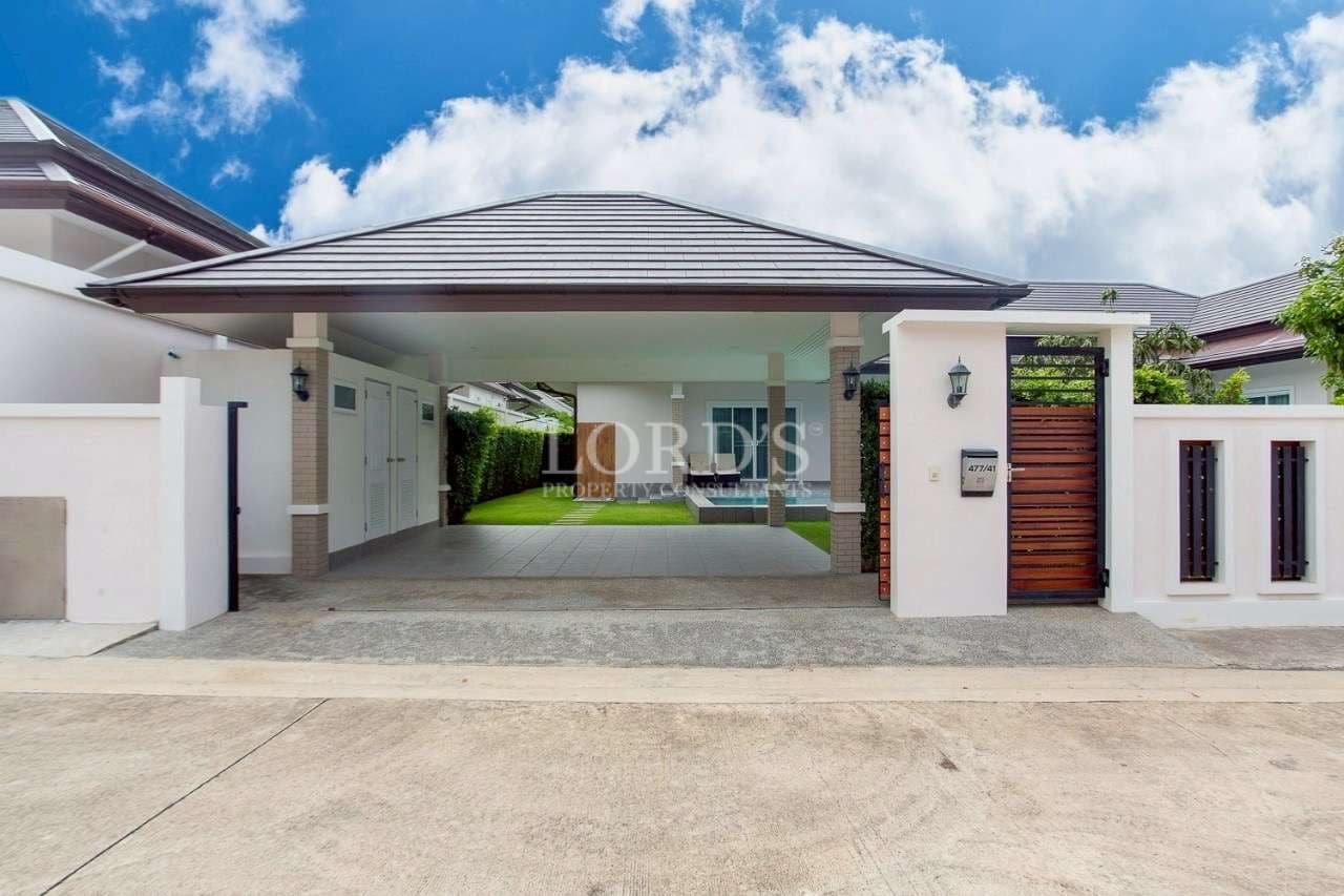 Modern single-storey villa entrance with covered carport, gated access, and clean contemporary facade.