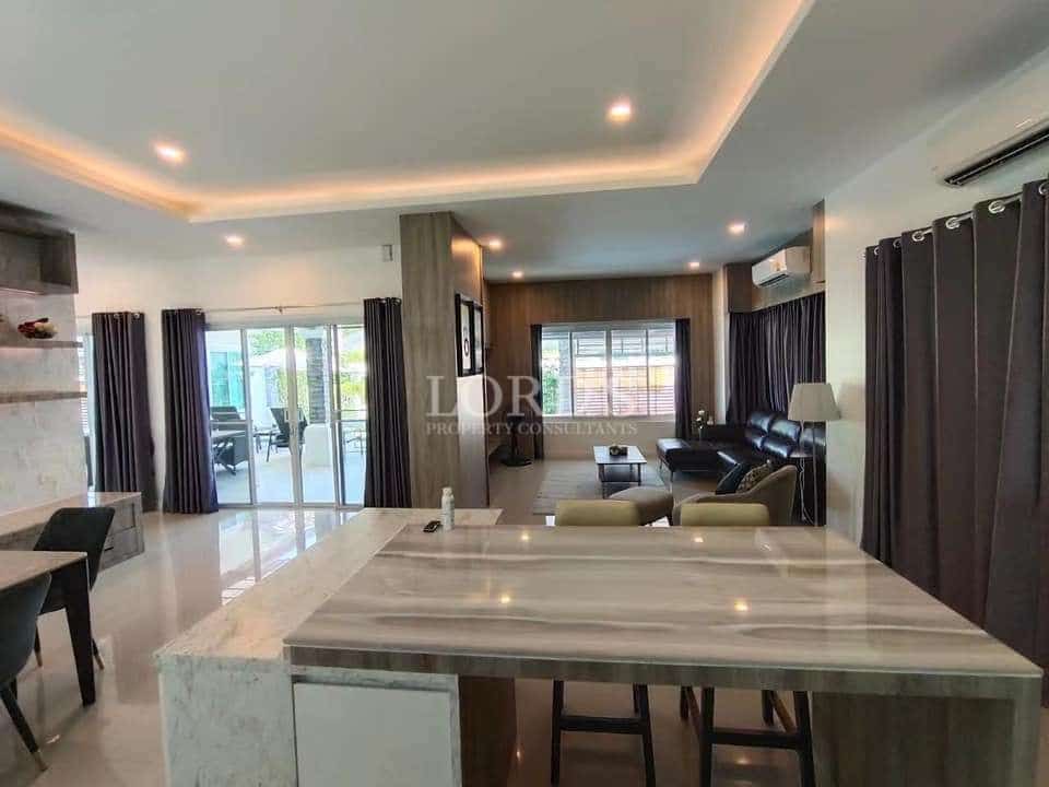 Open-plan living and dining area with modern kitchen island, recessed lighting, and sliding glass doors.