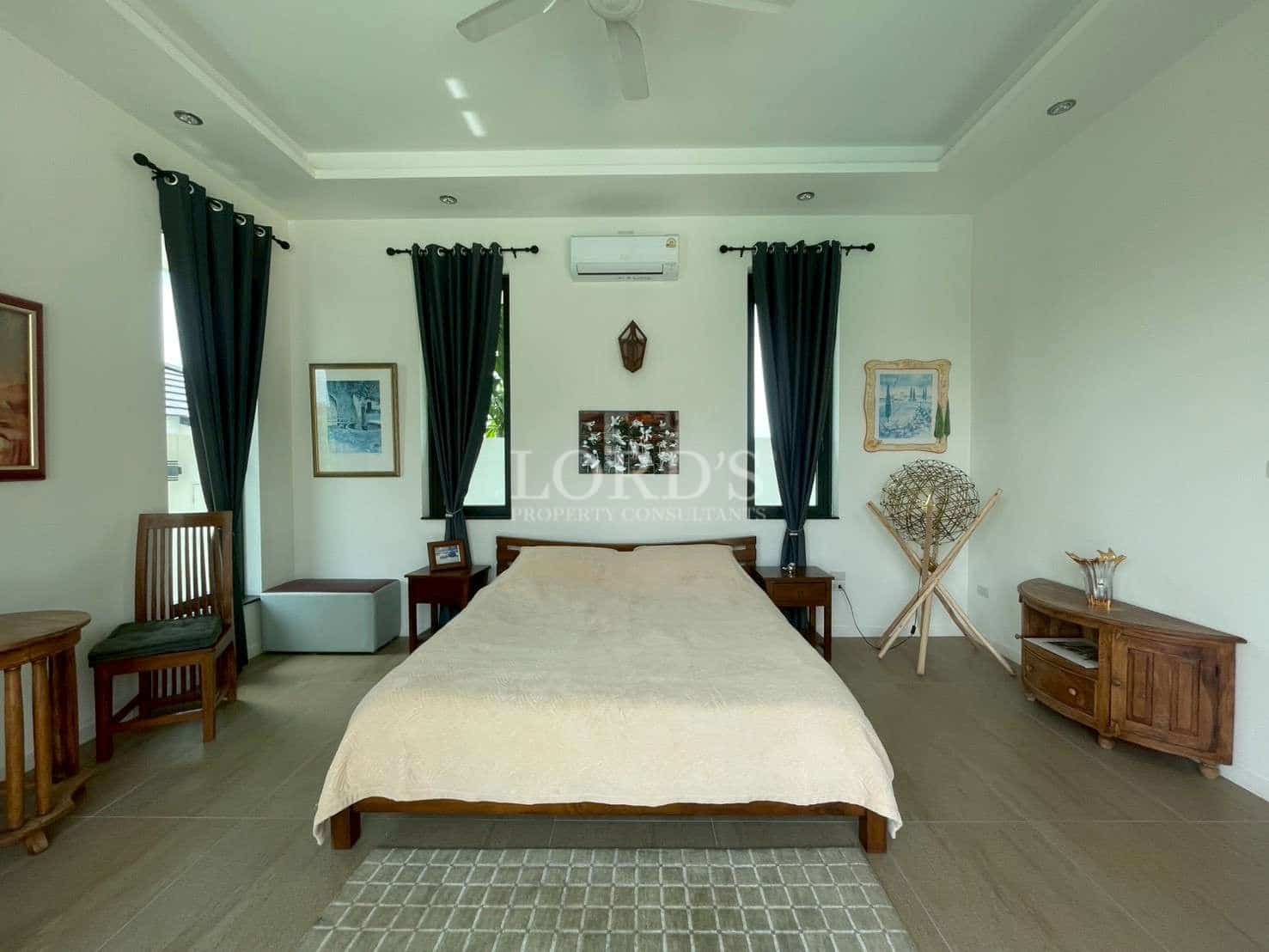 Spacious, modern bedroom with furniture.