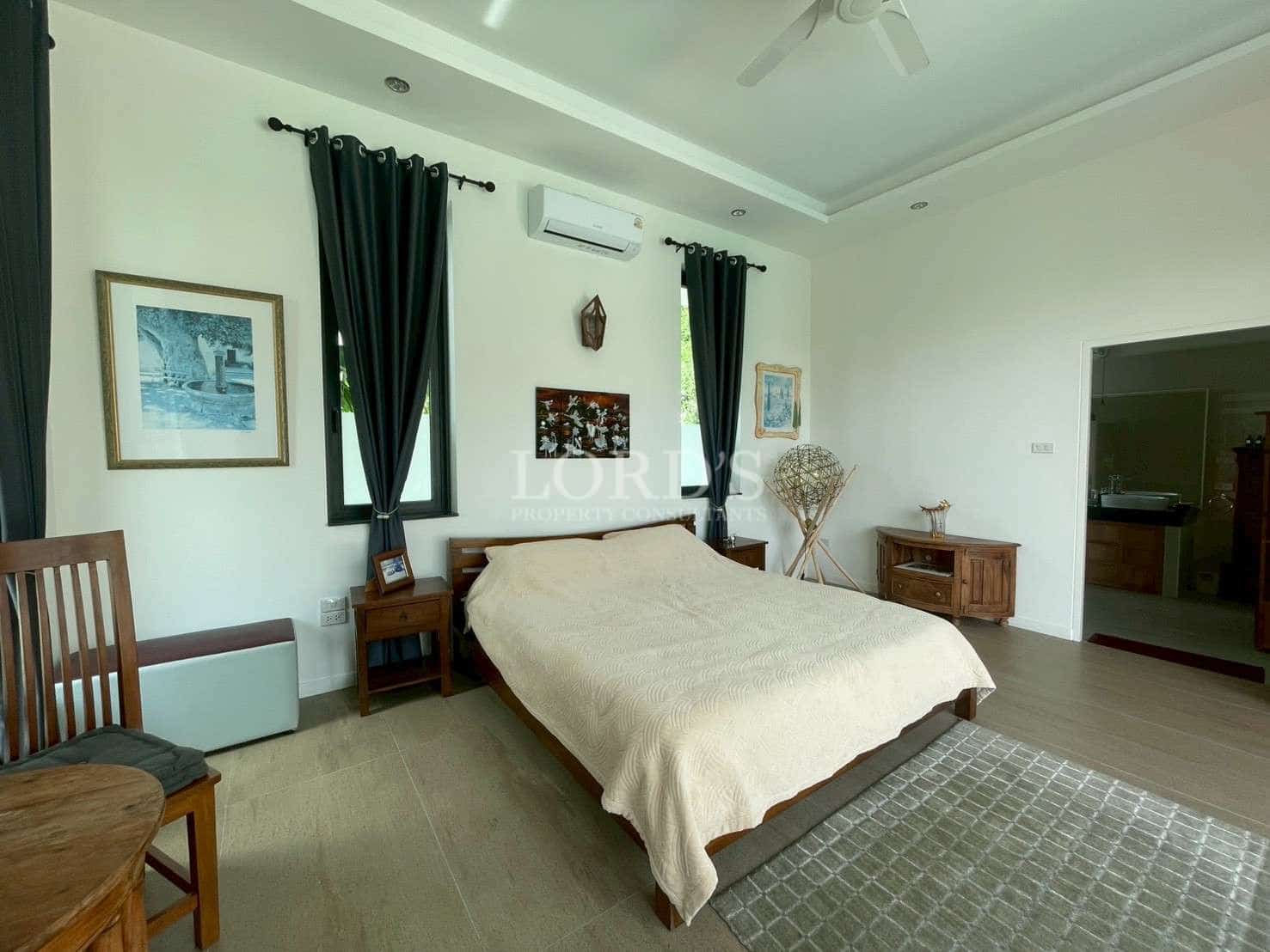 Spacious, modern bedroom with decor.