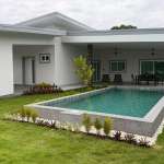 Modern single-story villa with raised private swimming pool, covered patio, and landscaped lawn.