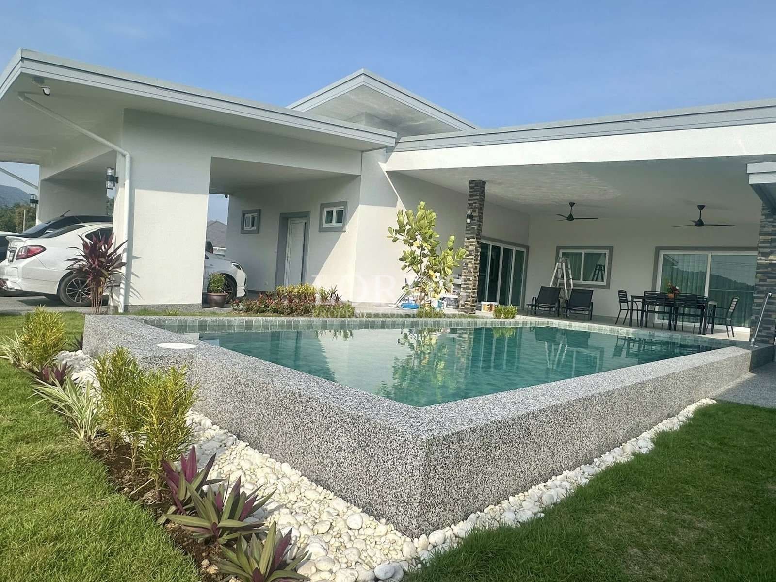 Modern single-story villa with raised private swimming pool, covered patio, landscaped garden, and contemporary architecture.