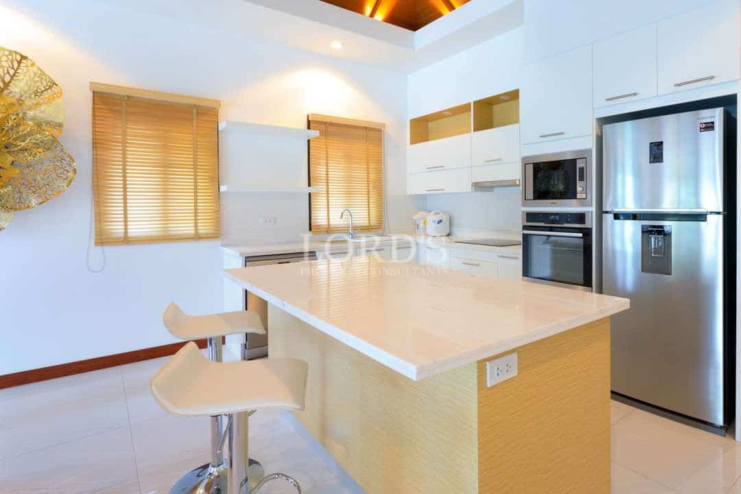 Modern luxury kitchen with island countertop, built-in appliances, and natural wood accents